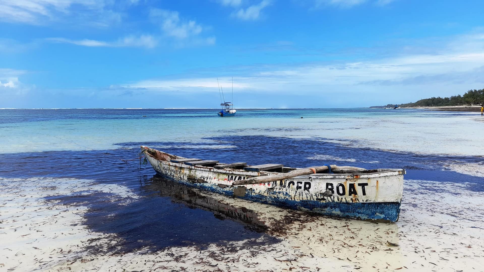 A wooden boat resting in turquoise shallows on Kenya’s south coast